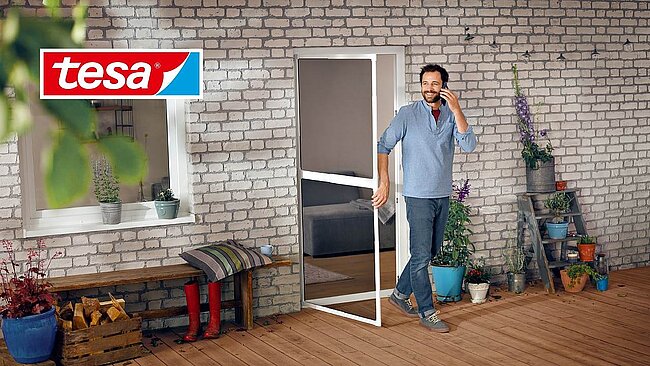 A man exits his home through a screen door, representing tesa SE’s innovative Insect Stop product equipped with a ValiGate® label. The integrated QR code on the label provides each product with a unique identity, enabling authentication, customer interaction, and access to exclusive content like installation guides and warranty extensions via the SCRIBOS 360 platform. This solution enhances the customer experience while ensuring protection against counterfeiting.