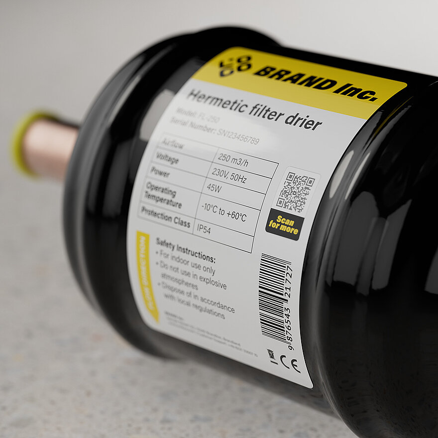 A hermetic filter drier with a detailed product label including specifications like voltage, operating temperature, and protection class. The label features a ValiGate® QR code from SCRIBOS, ensuring secure product authentication and access to digital information.