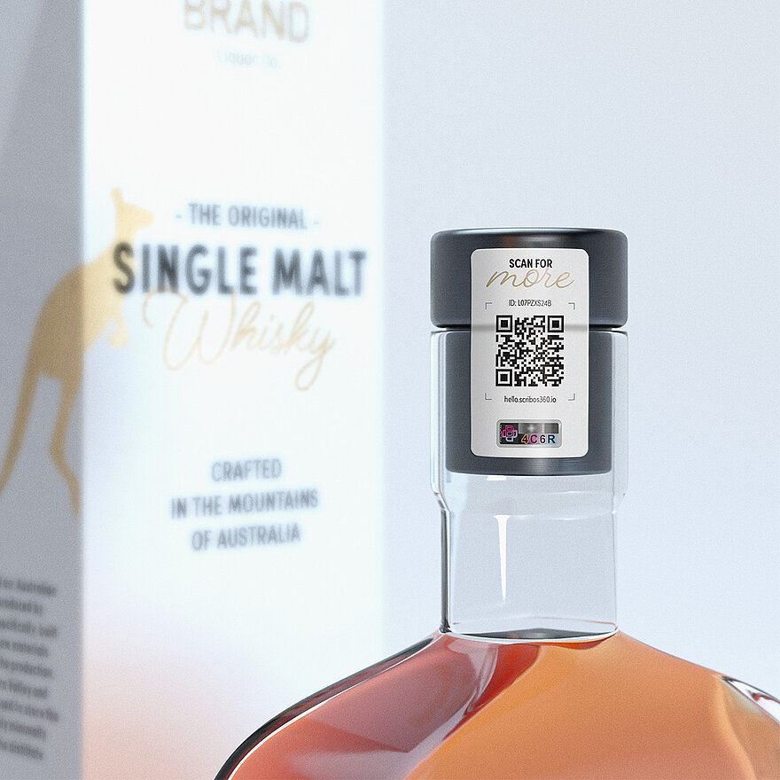 Gros plan d'une bouteille de whisky étiquetée « Single Malt Whisky » avec un bouchon noir. Le bouchon comporte une étiquette de sécurité affichant un code QR, un numéro d'identification de série (ID : L07PZXS248) et le texte « scanner pour en savoir plus ». L'étiquette intègre la technologie VeoMark®, avec un élément de sécurité alphanumérique visible (« 084C6R ») intégré pour la protection contre la contrefaçon. L'étiquette garantit une authentification conviviale du produit et renforce sa sécurité.