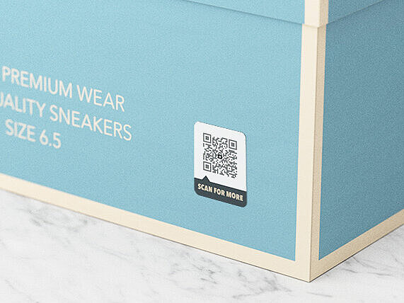 A light blue shoe box labeled “The Brand Shoes,” featuring size 6.5 and “Brand Premium Wear High Quality Sneakers” text. A QR code with an embedded ValiGate® security pattern is printed on the box. This integrated security feature ensures authenticity, protects against counterfeiting, and supports eco-friendly packaging design.